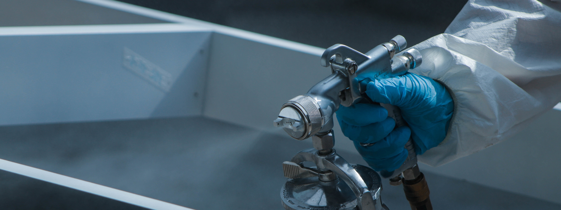 slide-2 Homem usando macacão e luvas enquanto faz pintura